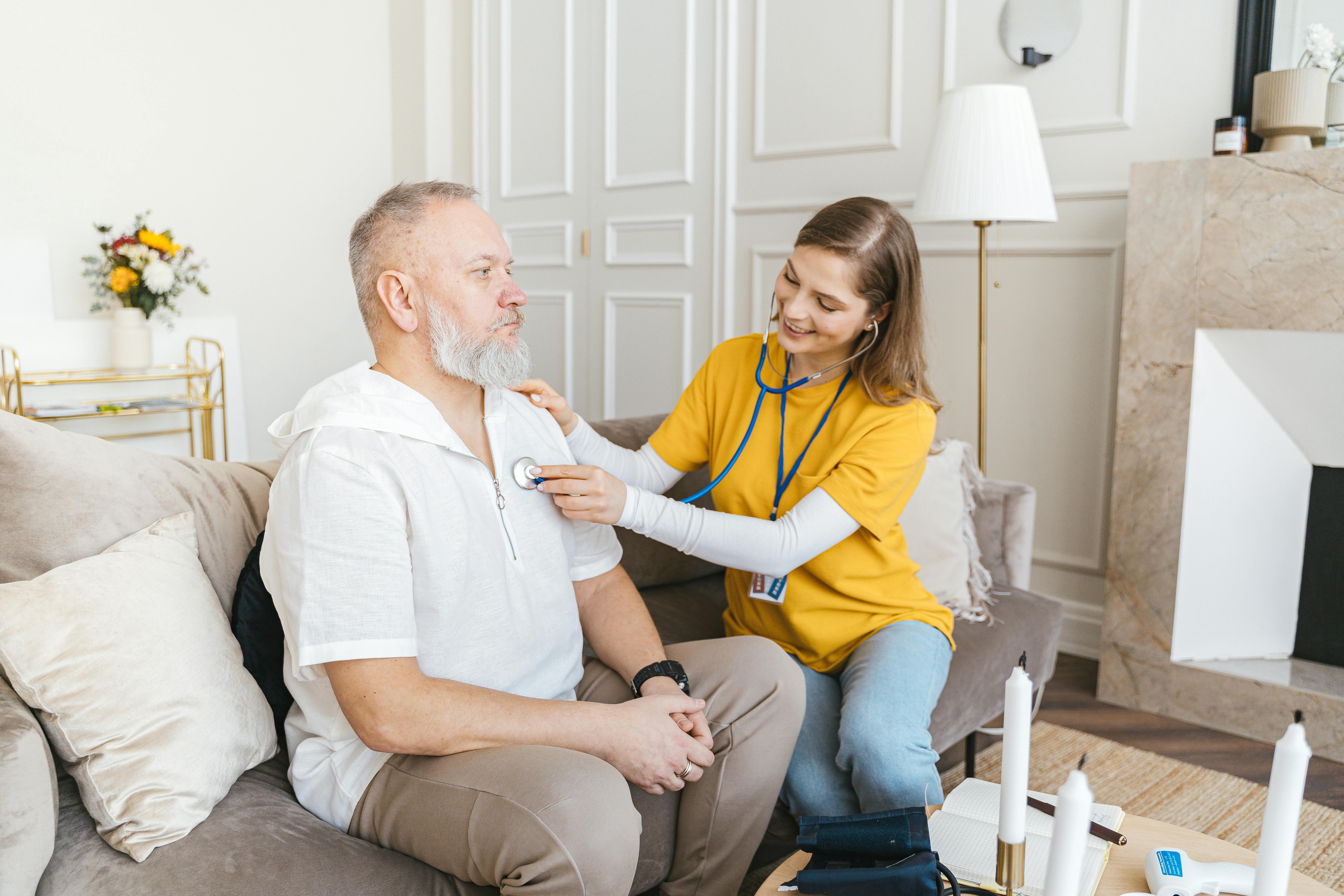 a nurse holding a stethoscope against a mans chest